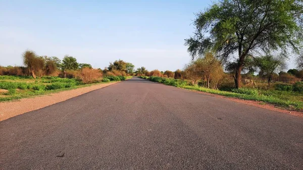 asphalt road in rural area of India with grunge on edges closeup