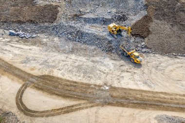 Drone fotoğrafı - kazıcı endüstriyel çöp kamyonuna ağır taşlar ve enkaz yüklüyor. Taşlar patlayan dağdan bedava şantiyeye kadar.