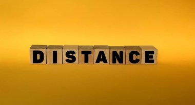 Sarı arka planda tahta bloklarda mesafeler. Sosyal mesafe kavramı..