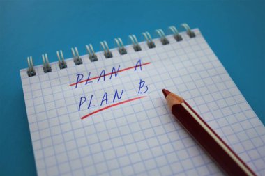 Bir hücrenin sarmal bir defterinde kırmızı kalem A planı ile işaretlenmiş, B planının altını çiz. Kırmızı kalem defterde, hepsi parlak mavi arkaplanda.
