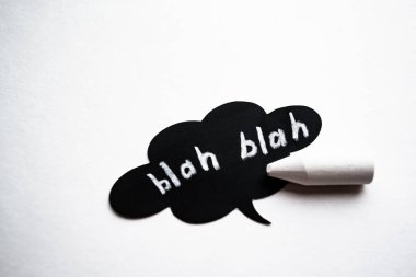 Beyaz arka planda siyah bulutlu konuşmalar ve beyaz tebeşirle yazılmış sözler. İletişim konsepti