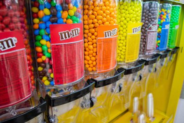 Moskova, Rusya, Kasım 2019: Süpermarketteki Candy Dispenser Machines 'de M & M Şekerleme' ye yakın çekim. Renkli düğme şekilli çikolatalar.