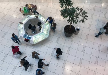 Moskova, Rusya, Ağustos 2019: Bir alışveriş merkezinde mücevher satan küçük bir satış noktasının üst görüntüsü. Etrafta alışveriş yapanlar, bir ağaç ve insanlar var.