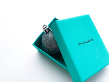 Moskova, Rusya, Ağustos 2019 Tiffany and Co mücevher markasının orijinal kutusu içinde parlak gümüş bir Noel balosu var. Hepsi beyaz arkaplanda