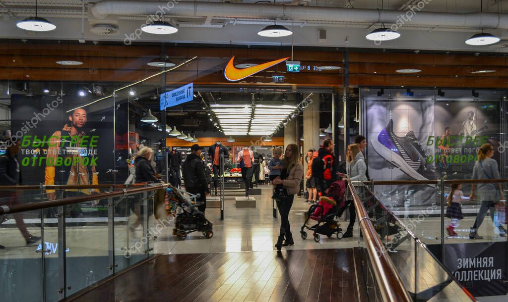 Moscow, Russia, November 2019: Brand store sportswear and footwear Nike. Entrance in the shopping mall, windows, storefronts, buyers look at the goods inside and go by outside
