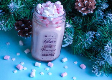 Moskova, Rusya, Ağustos 2019: Her zaman, kar taneleri ve kozalaklı köknar dallarıyla mavi bir zemin üzerinde bir fincan kakao ve marşmelov üzerine harika bir şey olacağına inandım.