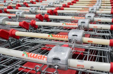 Moskova, Rusya, Haziran 2020: Kilitli Auchan alışveriş arabalarının kulplarında bozuk para işleten alıcıya yakın çekim