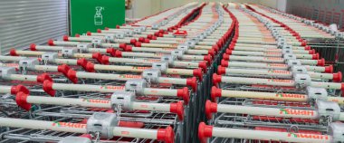 Moskova, Rusya, Haziran 2020: Yeşil hijyenik tedavi işaretinin yanında kilitleri ve bozuk para toplayıcıları olan bir sürü Auchan alışveriş arabası. Virüs koruması, güvenlik önlemleri ve müşteri hizmetleri kavramı