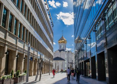 Moskova, Rusya, Temmuz 2020, Beyaz Meydan. Fütürist modern iş binaları ve eski bir Ortodoks Kilisesi 'nin birleşimi. Bulutlu mavi gökyüzü cam gökdelenlerin pencerelerinde sergilenir