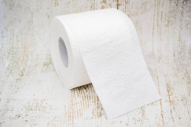 Beyaz tuvalet kağıdı rulosunun en üst görüntüsü ve eski ahşap arka planda delinme
