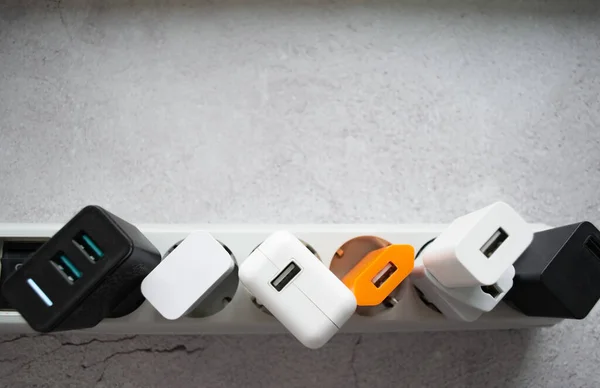 Birçok farklı USB DC çıkış portlarıyla modern eklenti güç şeridi çalıştırılıyor. Çatlamış beton arka plan. Boşluğu kopyala.