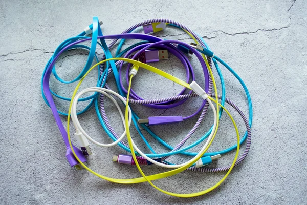 Montón Cables Colores Para Cargar Aparatos Sobre Fondo Hormigón Gris — Foto de Stock