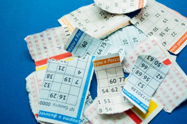 Koyu mavi arka planda numaraları olan piyango biletleri. Para ve şans kaybetme kavramı..