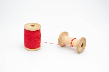 İki ahşap iplik makarası. Biri dolu, diğeri neredeyse boş, tek bir iplikle bağlanmış. Bir konsept olarak birliktelik, insanlar olmadan, insanlar olmadan.