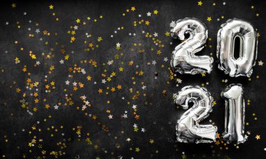 Yeni yıl 2021 'de şişme sayılar sağda. Parlak altın ve gümüş yıldızlı siyah arkaplan. Boşluğu kopyala.