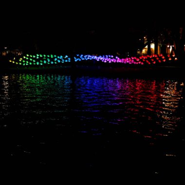 Amsterdam, Hollanda-14 Aralık 2014: Amsterdam Işık Festivali sırasında kanal üzerinde renkli kırmızı, mavi, yeşil ve mor renkli ampullerin büyük inşaatı.