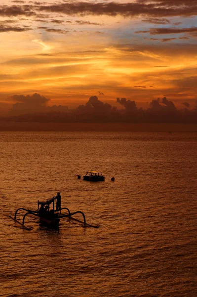 stock image Indonesian fishing boats silhouette at sea during sunset. They are arriving back from fishing trip at sea