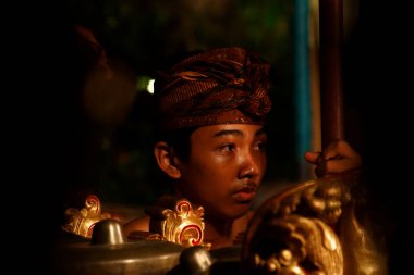 Ubud, Bali-Endonezya-Kasım. 13. 2014: Genç Asyalı görünümlü çocuk Ubud 'daki geleneksel Bali dansına yardım ediyor