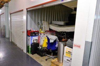 Bir depolama tesisinde açık kapısı ve ev eşyaları olan kapalı bir depo. Kiralık Depo Birimleri. Hollanda