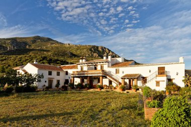 İspanya 'nın kırsal kesiminde, Finca Cortijo Las Monjas, Malaga, Endülüs, İspanya' da beyazlatılmış kır evi. Mavi gökyüzü gün batımında ılık.