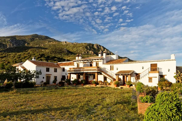 İspanya 'nın kırsal kesiminde, Finca Cortijo Las Monjas, Malaga, Endülüs, İspanya' da beyazlatılmış kır evi. Mavi gökyüzü gün batımında ılık.