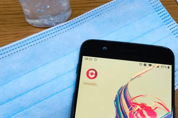 Bennekom, Hollanda, Aug, 20 bin 2020: Hollanda Corona izleme uygulamasının simgesi olan akıllı telefon: Coronamelder. Yüz maskesi, dezenfektan. Hükümet 1 Eylül 'deki uygulamayı tanıtmak istiyor. Mahremiyet sorunları.