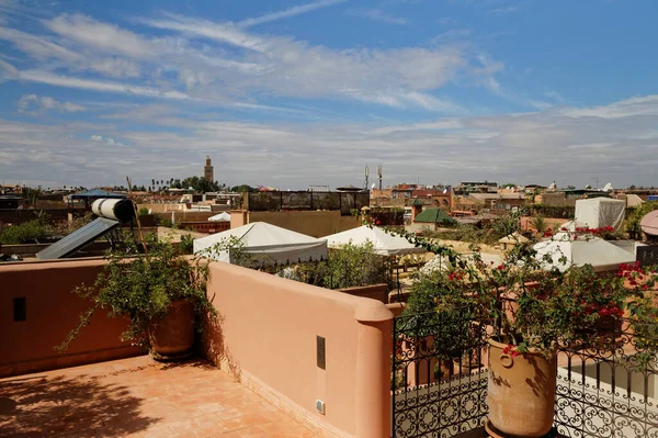 View of roof terrace in Marrakech. Morocco, close to the city centre. Rooftops with tent against shade and solar water heater and view towards Koutabia Mosque.