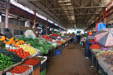 Agadir, Fas-Şubat 7.2019: Souk El Had, Agadir 'in merkezi. Pazar taze meyve, sebze, otlar ve geleneksel Fas ürünleri sunuyor. Çarşının yakınındaki büyük bir salonda sebze satan adamlar.