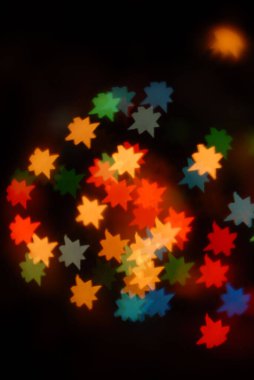 Bokeh yıldızları siyah arka planda renkli ışıklar, Noel