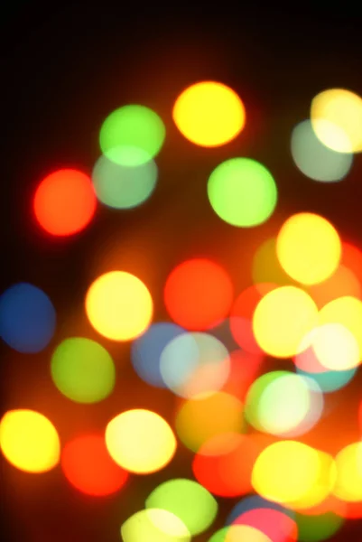 Bokeh, luces redondas de colores sobre un fondo negro, Navidad — Foto de Stock