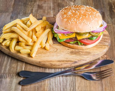 Taze lezzetli hamburger, domuz pastırması, peynir, domates, patates kızartması, soğan ve salata.