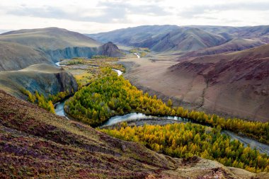 Güzel güneş vadisi ve açık nehir Kyzyltan dağların arasında yemyeşil bulutlarla. Altai sonbahar ormanı, sonbahar, macera, turizm.