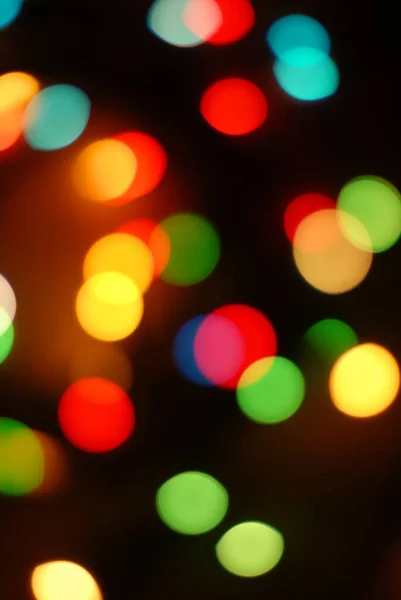 Bokeh, luces redondas de colores sobre un fondo negro, Navidad — Foto de Stock