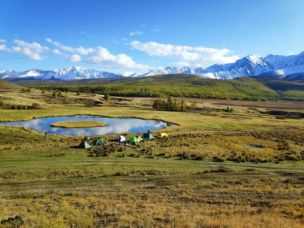 Altai, vista panorámica del lago y las montañas sobre el fondo del bosque, un campamento de campaña para turistas, otoño, cielo azul . — Foto de Stock