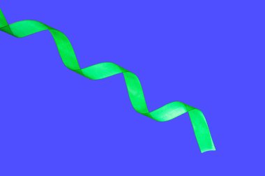 Yeşil ipek kurdele, mavi arkaplanda izole edilmiş kıvrım.