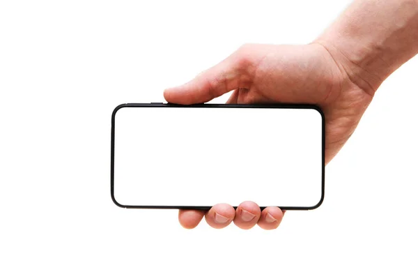 Una mano mans sostiene un teléfono inteligente con una pantalla vacía horizontalmente sobre un fondo blanco, primer plano de la mano. Espacio para texto — Foto de Stock
