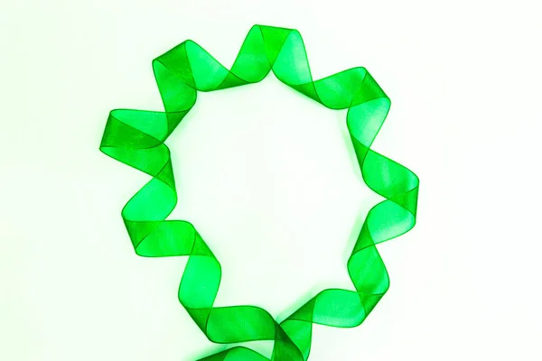Cinta de seda verde con remolinos alrededor del círculo, aislado sobre un fondo blanco — Foto de Stock