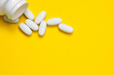 Sarı arka plandaki beyaz haplar ilk yardım çantasından düştü..