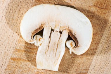 Tahta bir mutfak tahtasında doğranmış şampiyon.