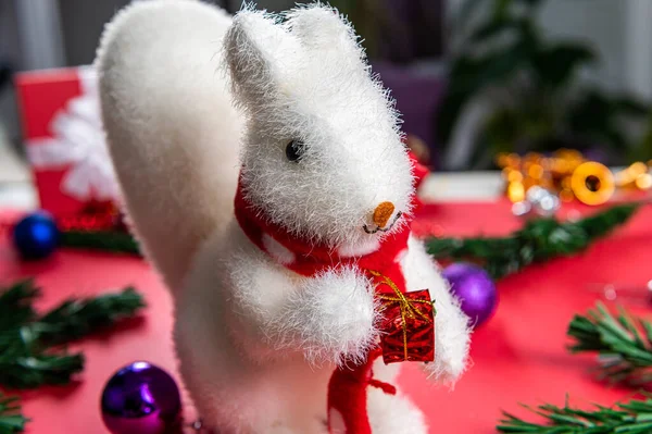 Juguete de Navidad ardilla blanca con un regalo rojo en sus patas. — Foto de Stock
