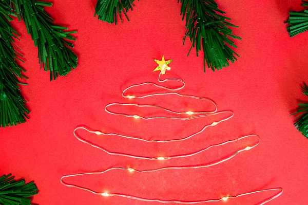 Árbol de Navidad de una guirnalda de Navidad sobre un fondo blanco rodeado de ramas de abeto, año nuevo, Navidad. — Foto de Stock