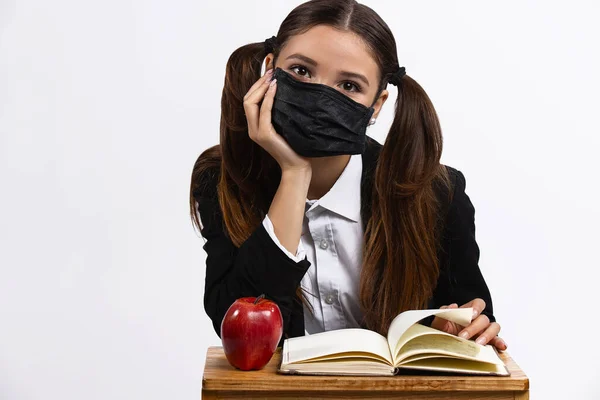 Menina com máscara protetora pronta para a lição da escola. Novas regras no sistema educacional. Fundo branco isolado — Fotografia de Stock