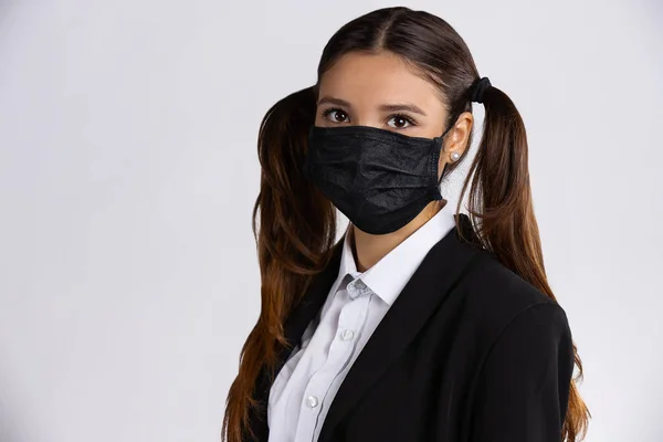 Menina com máscara preta no fundo branco isolado. Estudante bonito pronto para a escola — Fotografia de Stock