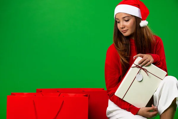 Presentes para todos. Jovem mulher olhando para os sacos de Natal com presente enquanto está de pé no chão — Fotografia de Stock