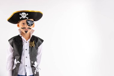 Cadılar Bayramı partisi. Korsan kostümlü ve yüzünde makyaj olan küçük bir çocuk Cadılar Bayramı partisinde iyi vakit geçiriyor. Yüz boyama çocuklar. Boş alana sahip izole edilmiş beyaz arkaplan.