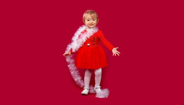 Hello December, awesome little girl welcome winter holidays. Christmas, sale and winter promotion concept on red background with plenty side space