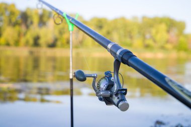 Yazın gölün arka planında makaralı olta.