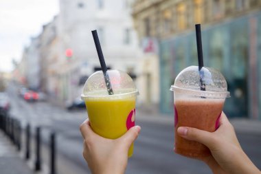 Bir kadının elindeki iki meyve püresinin yakın çekimi.