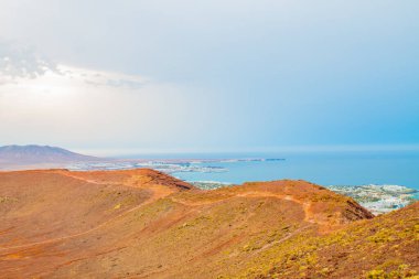 Volkan Montana Roja de Playa Blanca 'nın panoramik manzarası, Lanzarote, İspanya. Kanarya Adaları 'ndaki en popüler volkanlardan biri ve güneydeki beyaz evlerin toplam manzarası.. 