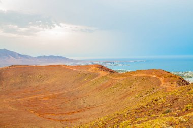 Volkan Montana Roja de Playa Blanca 'nın panoramik manzarası, Lanzarote, İspanya. Kanarya Adaları 'ndaki en popüler volkanlardan biri ve güneydeki beyaz evlerin toplam manzarası.. 